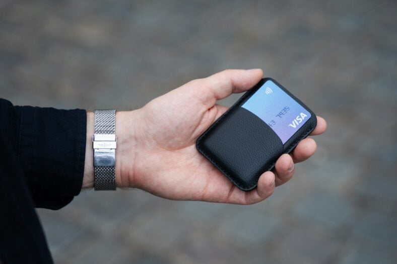 man holding visa card in wallet