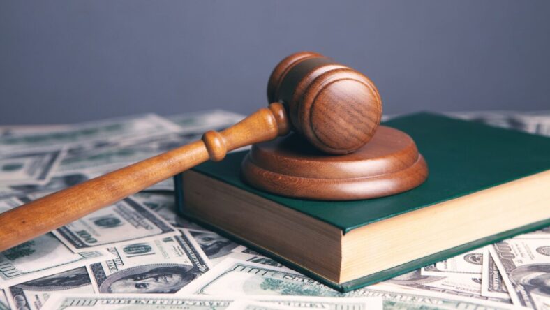 judge's gavel sitting on cash